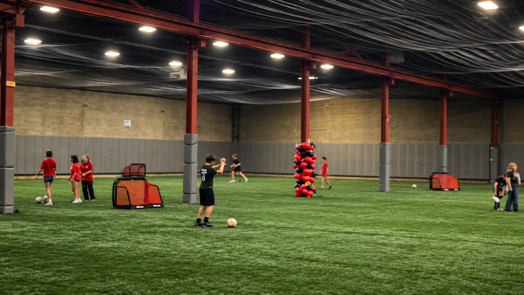 Cinematic AI-enhanced view based on the supplied photo of The Hub, showing the existing indoor turf, padded columns and training activity